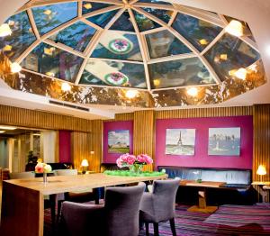 索非亚Eurostars Sofia City的餐厅拥有带桌椅的大型天花板。