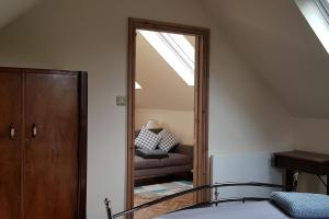 BlidworthThe Old School Loft的一间卧室配有镜子、一张床和一把椅子