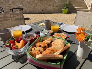 LiouxLE MAS AUX CEDRES - Teritoria的一张野餐桌,盘子里放有面包和水果