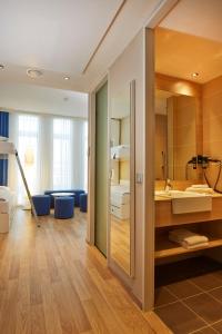 慕尼黑H2 Hotel München Messe的一间带大镜子和盥洗盆的浴室