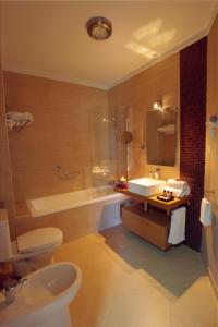 萨格里什萨格里什时代公寓酒店的浴室配有卫生间、盥洗盆和浴缸。