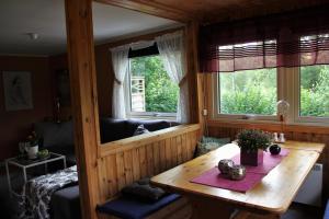 乌拉勒德Naturnära STUGA ULLARED的客房设有木桌和2扇窗户。