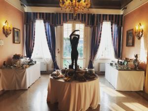 费拉拉Duchessa Isabella Collection by Uappala Hotels的桌子上有一个女人雕像的房间