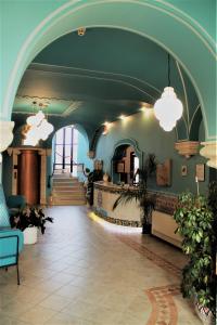 兰佩杜萨美杜莎酒店的大型大堂设有楼梯和蓝色天花板