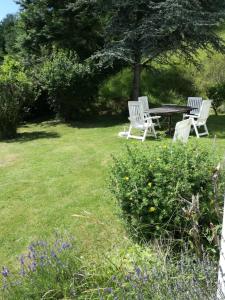TreignesLes Tiennes的两把白色椅子和一张院子里的野餐桌
