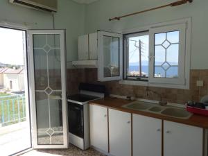 索瓦拉Sun and Sea的厨房配有白色橱柜、窗户和水槽