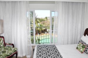 格罗斯岛可可棕榈的一间卧室设有一张床和一个大窗户
