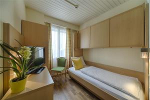 因特拉肯Hotel Blume Interlaken的小房间设有一张床和一把椅子