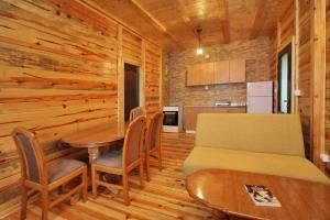 JevtićiTara lake apartments的一间设有桌子和床的房间和一间厨房