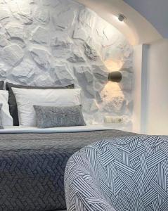 纳克索乔拉Marina's Suites的一间卧室设有一张床和石墙