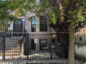 布鲁克林Brooklyn's Finest - Cozy 2 Bedroom的一座有树的建筑前的黑色栅栏