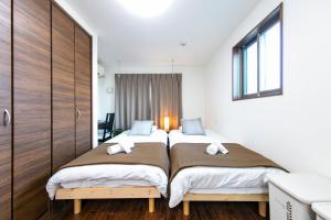 堺市高地HANA公寓的白色墙壁客房中的两张单人床