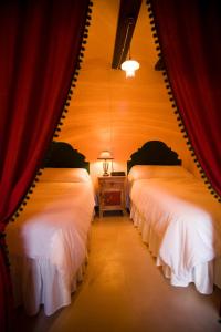 Tronchón马克瓦尔迪奥利沃度假屋的红色窗帘间内的两张床