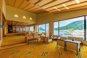 沼津伊豆三津浜松涛酒店的配有桌椅的教室,享有水景