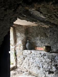 Santa-Lucia-di-Mercurio,A cantinella, une cave a fromage au centre corse的石墙,花瓶坐在架子上