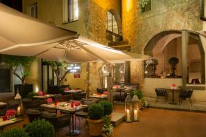 佛罗伦萨Brunelleschi Hotel的一间带桌椅和遮阳伞的餐厅