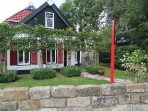 GorredijkB&B Singelstate的石墙前有标志的房子