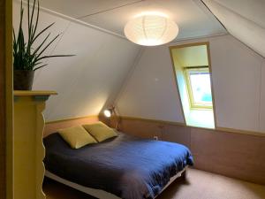 达尔夫森Boerderij met atelier的一间卧室设有床、窗户和一盏灯。