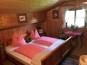 平茨高谷地霍勒尔斯巴赫Senninger Alm的一间卧室配有一张带红色枕头的大床