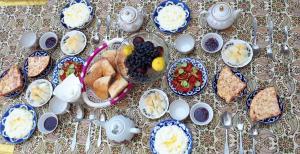 布哈拉Bobo Haydar Guest House的一张带蓝色和白色食物板的桌子