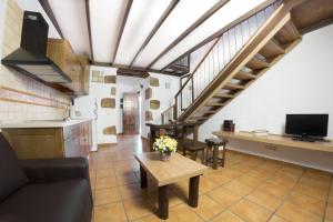 圣巴托洛梅Casa rural en Hoya de Tunte 3的厨房以及带沙发和桌子的客厅。