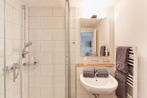 黑尔戈兰岛Hotel Helgolandia的白色的浴室设有水槽和淋浴。