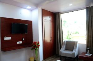 萨瓦伊马多普尔Meera Mahal的客房设有电视、椅子和窗户。
