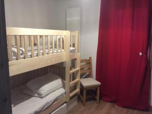 普拉波特尔les 7 laux immobilier chalet E的一间卧室设有两张双层床和红色窗帘