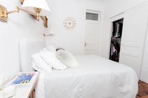 博索莱伊Charmant 2 pieces frontiere Monaco的白色卧室,床上配有白色枕头