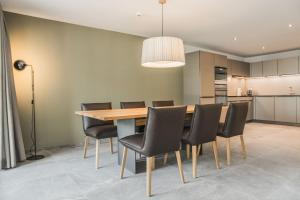 因特拉肯Apartment JungfrauCenter Roteflue - GriwaRent AG的用餐室配有木桌和黑椅子