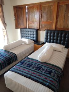 班图尔JOGLOPARI GuestHouse bukan untuk pasangan non pasutri的两张睡床彼此相邻,位于一个房间里