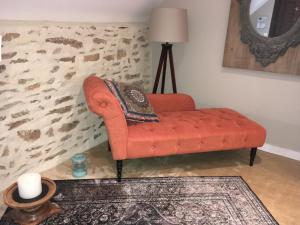 Grand-ChampLes Dames de Nage的客厅里一张橙色的长沙发,墙上挂着