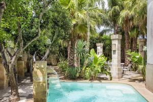 VitiglianoSalento Exclusive Villa Monika的棕榈树花园内的游泳池