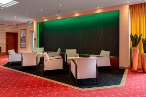 巴特法兴格Hotel Schweizer Hof Thermal und Vital Resort的一间会议室,配有椅子和绿屏幕