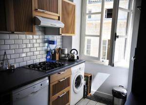 波尔多Burdigala Homes - Appart Sainte Catherine的厨房配有炉灶和洗衣机。