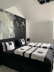 爱尔福特Luxus Appartement Brühlervorstadt Erfurt的一间带两张床和一张男士海报的卧室