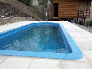 Alto La ViñaCabañas Rosaverde的一座带房子的庭院中的蓝色游泳池