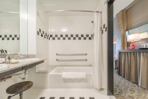 格林斯伯勒普罗西米特酒店的白色的浴室设有浴缸和水槽。