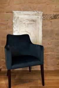 特罗吉尔Villa Teuta的砖墙前的蓝色椅子