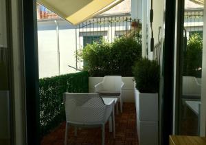 卡瓦德蒂雷尼Le Suite del Duomo的一座带白色椅子和植物的庭院