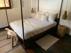 Ile aux NattesVilla Voanio的卧室配有带白色床单和枕头的天蓬床。