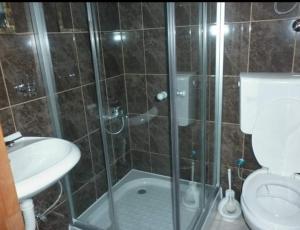 乌尔齐尼Apartments EMERALD的带淋浴、卫生间和盥洗盆的浴室