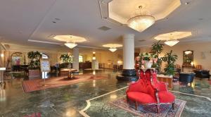 弗利格洛伯斯城贝斯特韦斯特酒店的中间设有红色椅子的大堂