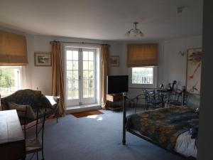 泰晤士河畔沃尔顿The Weir Hotel的卧室配有一张床和一张桌子及椅子