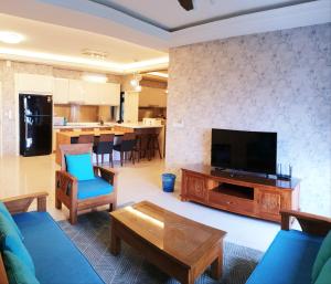 努沙再也Meridin的客厅配有电视、沙发和桌子