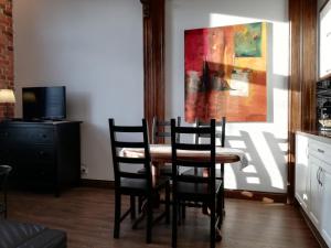 比得哥什Apartamenty Bydgostia的餐桌、椅子和墙上的绘画