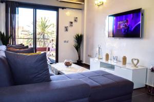 马拉喀什Apartment in Marrakesh, Gueliz的客厅配有沙发和墙上的电视