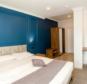 KojoriThe Residence Hotel & Cottages的卧室拥有蓝色的墙壁和白色的床。
