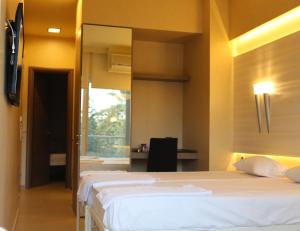 苏达Oneiro Suites的一间卧室配有两张床和镜子