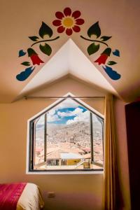 库斯科Cusco Plaza Nazarenas的卧室设有墙上鲜花窗户